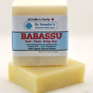 May include: A white bar of Babassu hair, face, and body soap. The label reads "All Profits to Charity" and "Dr. Stamler's Sensitive Skin Care". The soap is unscented, dye-free, coconut-free, low comedogenic, and made with 100% organic oils and butters. The bar weighs 4 ounces or 113 grams.