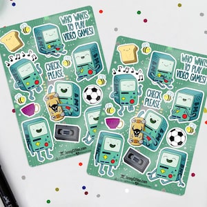 Puede incluir: Dos hojas de pegatinas con fondo verde con consolas de videojuegos de dibujos animados, tostadas, abejas, balones de fútbol y el texto "WHO WANTS TO PLAY VIDEO GAMES!" y "CHECK PLEASE". Las pegatinas tienen un tema de videojuegos retro.