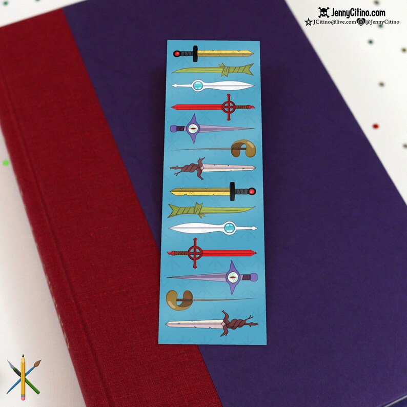 May include: A blue bookmark featuring various cartoon sword designs in gold, green, red, and purple. The bookmark is placed on a purple book with a red cover. The text "JennyCitino.com" is visible in the upper right corner.