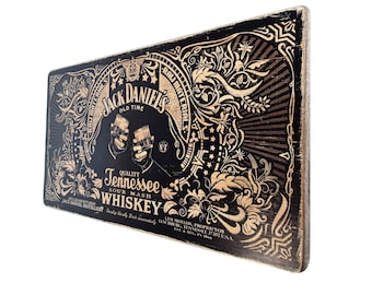 May include: A vintage-style sign with a black background and gold lettering. The sign features the Jack Daniel's logo and the text "Tennessee Sour Mash Whiskey". The sign is decorated with ornate floral designs.