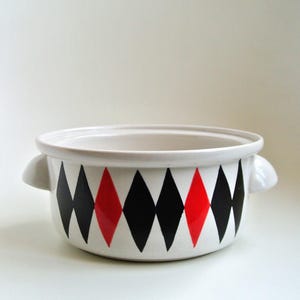 May include: White ceramic serving bowl with black and red diamond pattern. The bowl has two handles.