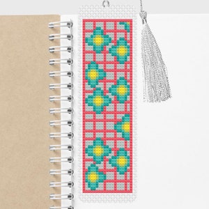 May include: A red and white bookmark with a teal and yellow geometric pattern. The bookmark has a tassel.