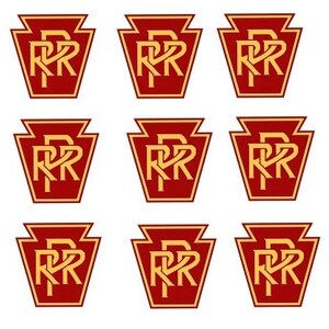 May include: Nine red and gold Pennsylvania Railroad logos with the letters "PRR" in a stylized font.