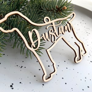 May include: A wooden dog ornament with the name "Dustin" cut out in cursive script.