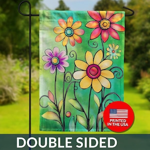 May include: Double-sided garden flag featuring a colorful floral design. The flag displays vibrant flowers in shades of yellow, pink, orange, and purple against a green background. The text "DOUBLE SIDED" is at the bottom, with a "PRINTED IN THE USA" emblem.