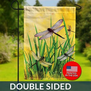 May include: Double-sided garden flag featuring a watercolor design of dragonflies and tall green grass against a yellow background. The flag has the text "DOUBLE SIDED" and a "PRINTED IN THE USA" graphic.