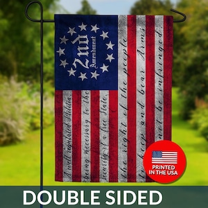 May include: Double-sided garden flag featuring the American flag design with the text of the 2nd Amendment. The flag has a blue field with white stars and red and white stripes. The text includes "A well regulated Militia" and "the right of the people to keep and bear Arms."