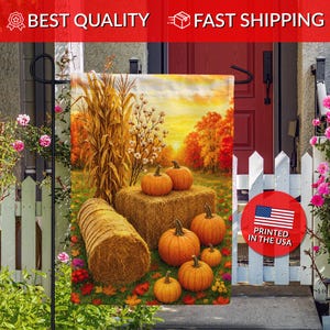 May include: A rectangular garden flag featuring an autumn scene with orange pumpkins, hay bales, and corn stalks under a golden sunset sky. A red circular emblem on the flag displays the text PRINTED IN THE USA with a graphic of the American flag.