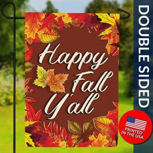 May include: Double-sided garden flag with a brown background and the words "Happy Fall Y'all" in white script. The flag is decorated with colorful autumn leaves in shades of red, orange, and yellow. A red circle with the American flag is in the bottom right corner.