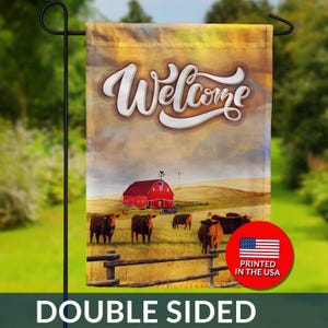 May include: Double-sided garden flag with a pastoral scene. The flag features a red barn, cows, and the word "Welcome" in white script. The flag is printed in the USA.