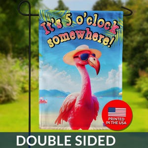 May include: Double-sided garden flag featuring a pink flamingo wearing sunglasses and a hat, with the text "It's 5 o'clock somewhere!" against a beach scene backdrop. Includes a "Printed in the USA" logo.