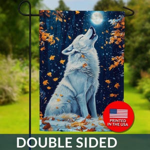 May include: Double-sided garden flag featuring a white wolf howling at the moon in a forest scene with falling autumn leaves. The flag has a dark blue background and the text "DOUBLE SIDED". A red circle with the American flag and the text "PRINTED IN THE USA" is also visible.