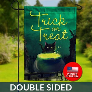 May include: Double-sided Halloween garden flag featuring a black cat peering over a bubbling cauldron with the words "Trick or Treat" in yellow script. The flag has a green background and a red circle with "Printed in the USA".
