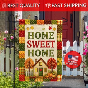 May include: A rectangular garden flag featuring a patchwork border in autumn colors of orange, yellow, and green. The center displays the text "HOME SWEET HOME" above a house illustration with trees, pumpkins, and a white fence on a cream background.