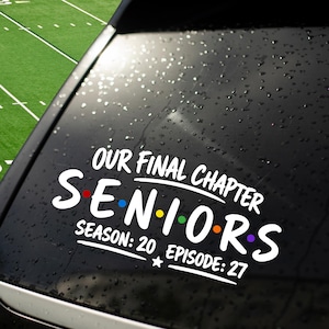 May include: A white vinyl decal applied to a car window featuring the text OUR FINAL CHAPTER SENIORS SEASON: 20 EPISODE: 27. The word SENIORS includes small colored dots between the letters in red, blue, yellow, green, orange, and purple.