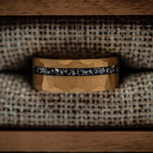 8mm Gold Hammered wedding ring with silver meteorite inlay in a walnut ring box between burlap cushion