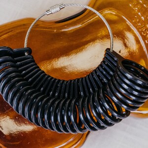Black Ring sizer with sizes 4 to 13