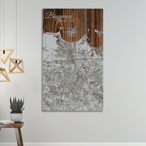 May include: A wood wall art piece featuring a detailed map of Bayamon, Puerto Rico. The map is laser cut into the wood and has a compass rose in the center. The text "Bayamon, Puerto Rico" is written at the top of the map.