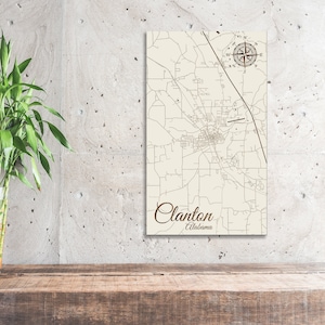 May include: A vintage-style map print of Clanton, Alabama, with a compass rose in the top right corner. The map is printed on a cream-colored background with brown lines and text.