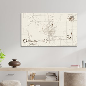 May include: A vintage-style map print of Chillicothe, Missouri, with a compass rose in the top right corner. The map is printed on a cream-colored background with brown lines and text.
