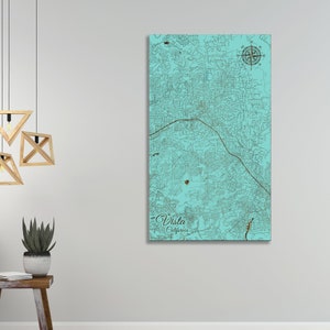 May include: A teal blue map of Vista, California with a compass rose in the top right corner. The map is printed on wood and has a rustic, vintage look.