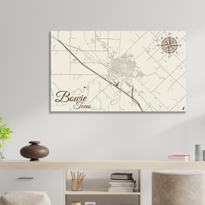 May include: A beige map of Bowie, Texas with a compass rose in the top right corner. The city name is written in cursive script below the map.