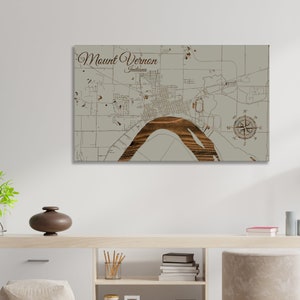 May include: A wood-mounted map of Mount Vernon, Indiana, with a compass rose and a brown river winding through the city. The map is on a light gray background.