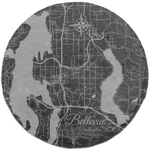 May include: A black and white map of Bellevue, Washington, on a round slate coaster. The map shows the city's streets and waterways. The text "Bellevue, Washington" is printed in white at the bottom of the coaster.