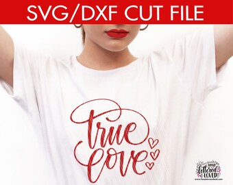 Könnte beinhalten: Roter und weiß gestreifter Text, der "True Love" mit kleinen Herzen um den Text herum sagt. Der Text befindet sich auf einem weißen T-Shirt.