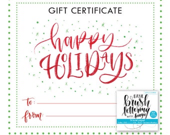 Könnte beinhalten: Ein weißes Geschenkgutschein mit einem roten und grünen Weihnachtsmotiv. Der Text "Happy Holidays" ist in roter Kursivschrift geschrieben. Der Gutschein hat einen Platz zum Schreiben von "an :" und "von :". Ein kleines Bild eines Buches mit dem Titel "Basic Brush Lettering with Tanya" befindet sich in der unteren rechten Ecke.