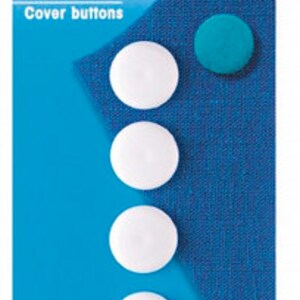 Puede incluir: Cinco botones de cobertura blancos, de 15 mm de diámetro, sobre un fondo de tela azul. Los botones son para cubrir y se venden en un paquete etiquetado como "Botones de cobertura".