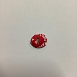 Può includere: Un bottone rosso a forma di pesce con dettagli bianchi incisi. Il bottone presenta un occhio rotondo, una pinna e una coda. Il bottone ha due fori per cucire. Questo bottone è ideale per progetti di cucito.