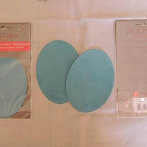 May include: Two packages of iron-on elbow patches. The package on the left shows three blue elbow patches. The package on the right has a white background with black text that reads "Pic & Malice" and a pink logo that reads "Paritys".