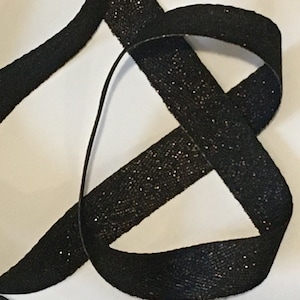 May include: Black ribbon with a subtle sparkle finish. The ribbon is approximately 1 inch wide.