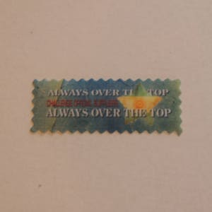 Peut inclure: Un autocollant bleu et vert avec une étoile et le texte "ALWAYS OVER THE TOP" en lettres blanches.