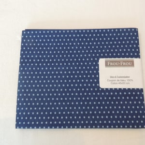 May include: A blue fabric with white polka dots. The fabric is labelled "Frou-Frou Deco & Customization Coupon de tissu 100% Coton 45x53 cm".