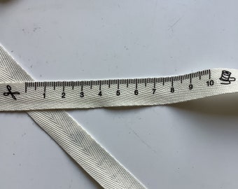 Woven ribbon, polyester, tape measure pattern, ecru and black color, width 15 mm