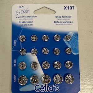 Può includere: Una confezione di bottoni a pressione assortiti in nichel in varie misure: 8 mm, 10 mm e 12 mm. La scheda presenta testo in più lingue, tra cui "Snap fastener" e il marchio "Célia's".