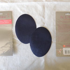 May include: Two dark blue iron-on patches for clothing repair. The patches are round and come in a package with instructions on how to use them. The package is labeled "Pic & Malice" and "Parity's".