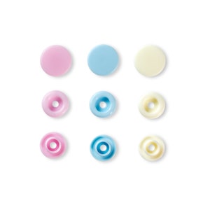 May include: Nine plastic snap buttons in three colours: pink, light blue, and cream. The buttons are arranged in three rows of three.