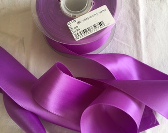 Puede incluir: Una bobina de cinta de satén morado, de 50 mm de ancho, 100 % poliéster. La etiqueta dice "Art 110, 12, 25 mtr., (50 mm) 100% POLYESTER, Col. 94, 3435024732750".