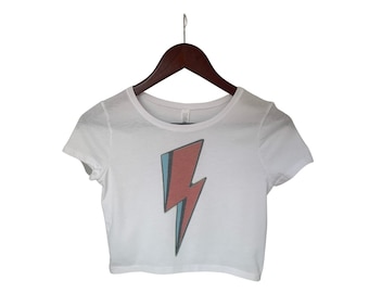 May include: White cropped t-shirt with a red, blue, and white lightning bolt graphic.