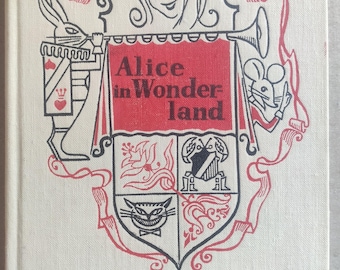 May include: Vintage hardcover book, "Alice in Wonderland," featuring a red and black illustrated cover. The cover design includes a portrait of Alice, the White Rabbit, and the Cheshire Cat, with the title prominently displayed.