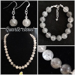 Könnte beinhalten: Ein Schmuckset mit einer Halskette, einem Armband und Ohrringen aus klaren Quarzperlen. Der Schmuck ist mit "Quartz Cloud" beschriftet.