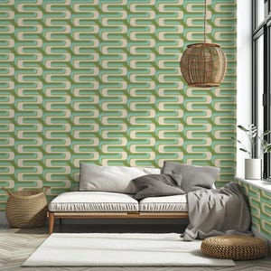 Puede incluir: Salón con papel pintado retro con un patrón repetitivo de formas curvas verdes, turquesas y crema. Un sofá blanco con cojines grises, una lámpara colgante de mimbre y una cesta completan la decoración.