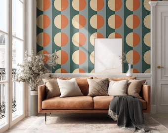 May include: A living room with a brown leather sofa, pillows, and a patterned rug. The wall features a retro design with orange and cream-colored half-circles against a teal background. A blank framed picture hangs on the wall.