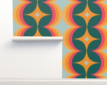 Può includere: Un rotolo di carta da parati con un motivo geometrico ripetitivo di cerchi e stelle intrecciati in tonalità verde scuro, arancione, rosa e azzurro, parzialmente srotolato contro una superficie murale bianca liscia.