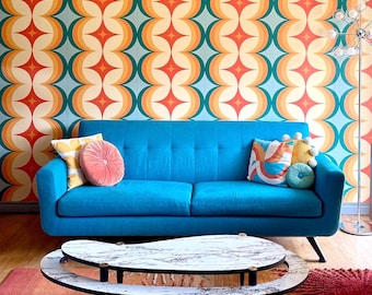 Può includere: Un divano blu brillante con due cuscini trapuntati, completo di un cuscino rotondo rosa, un cuscino giallo a motivi e due cuscini rotondi più piccoli in blu e giallo. Un tavolino da caffè a due livelli a forma di rene con piano in marmo bianco.