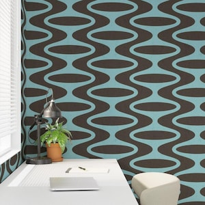 May include: Wallpaper featuring a repeating pattern of dark brown horizontal ovals connected by vertical wavy lines against a light blue background. The design is displayed on a wall behind a desk with a lamp, a potted plant, and a laptop.