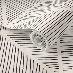 Puede incluir: Un rollo de papel tapiz blanco con un patrón geométrico en blanco y negro de líneas diagonales.